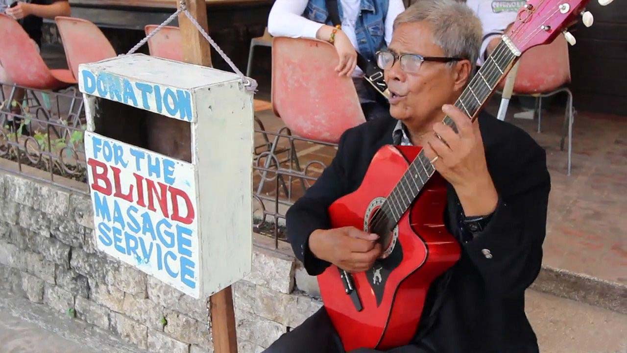 Watching a Cebu Blind Singer perform on his guitar in the streets