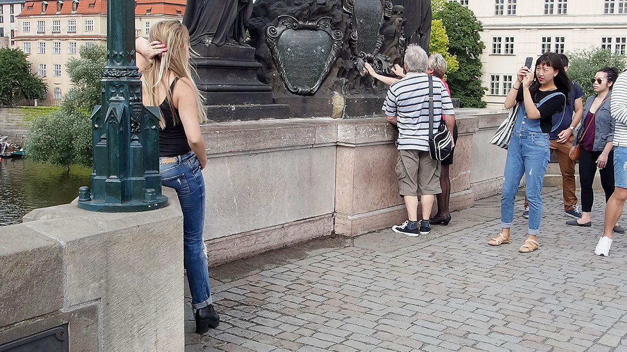 Sexy girl posing for photo at Prague Bridge