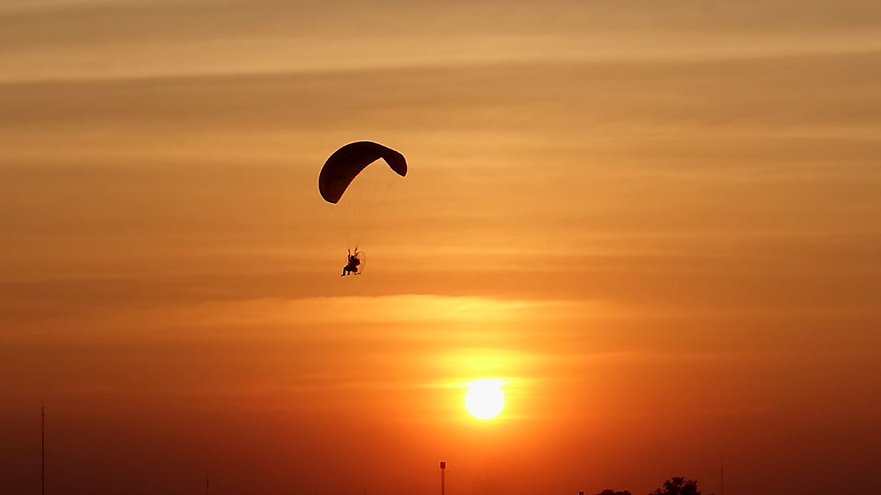 Flying men up in the clouds at sunset