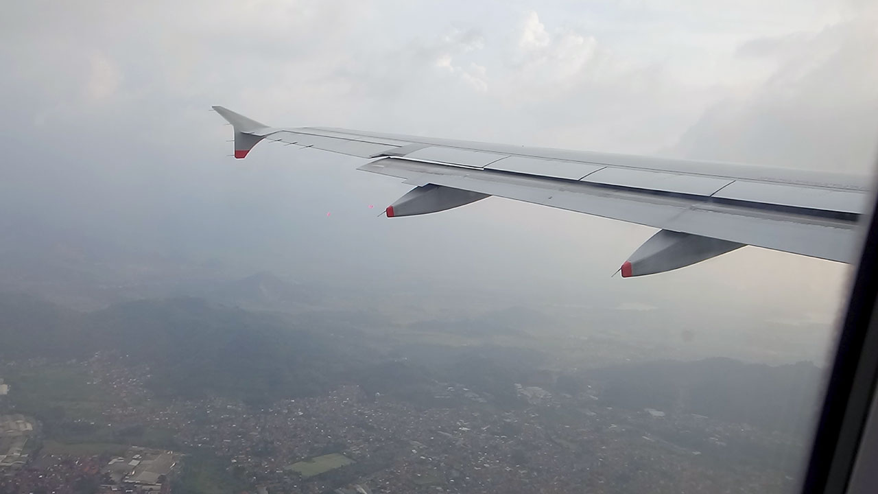 View of plane wing from window on FLIGHT LEAVING BANDUNG airport