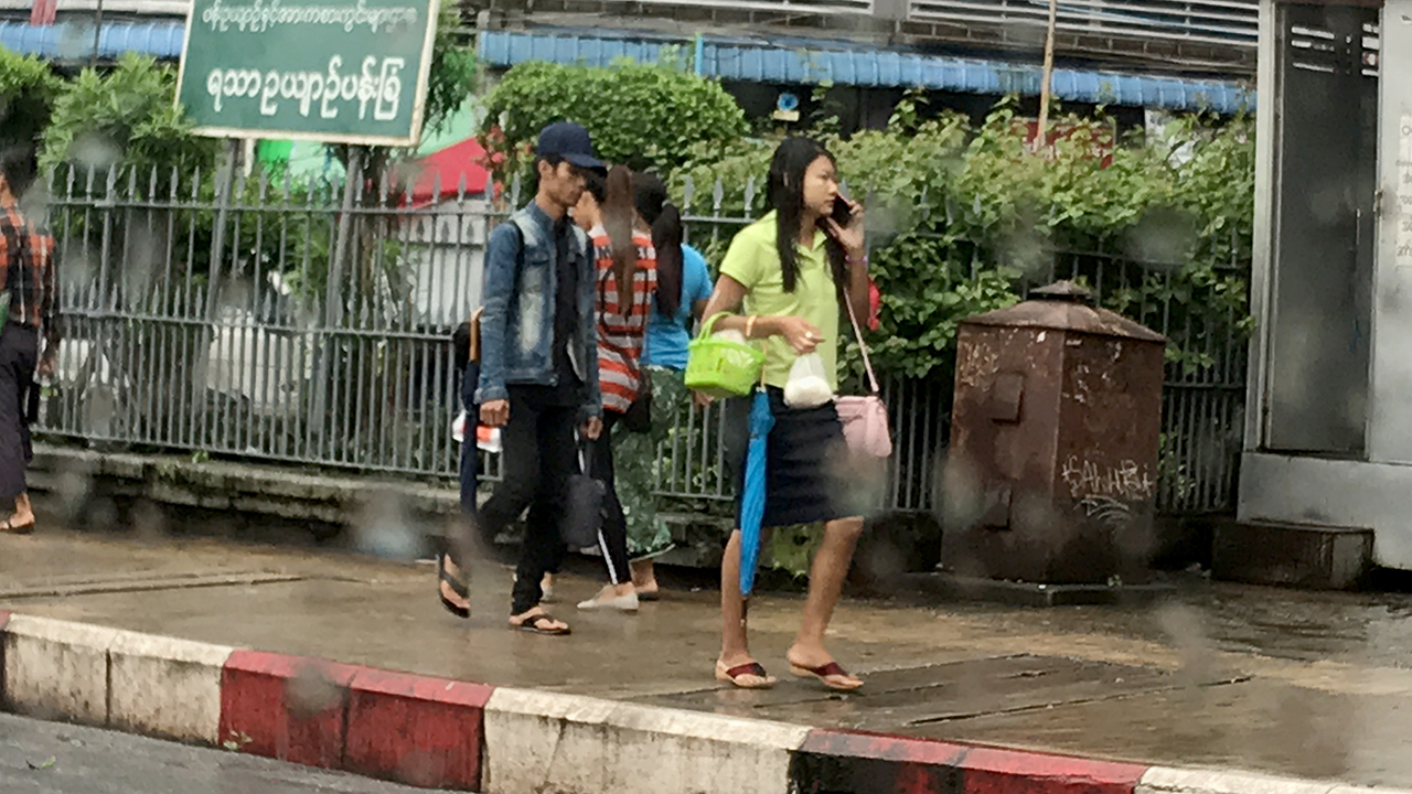 Yangon Myanmar street view of pretty Burmese girl in skirt