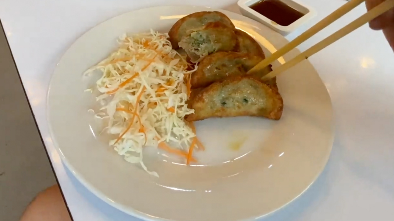 Plate of Bangkok Gyoza probed with chopsticks
