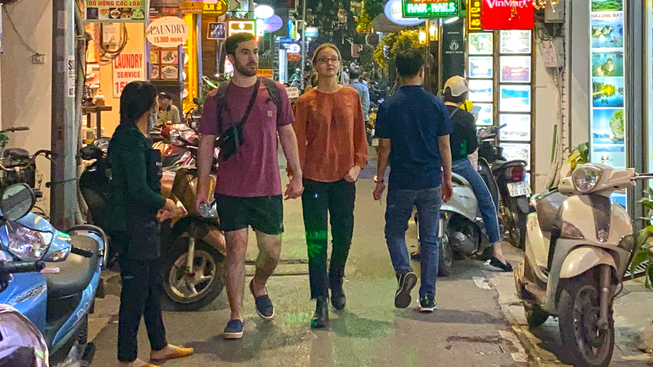 Interacial white Vietnamese couple holding hands on Hanoi Nightwalk