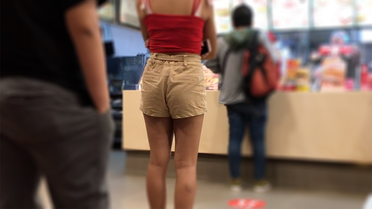Cute Girl Standing in line wearing short shorts at burger place