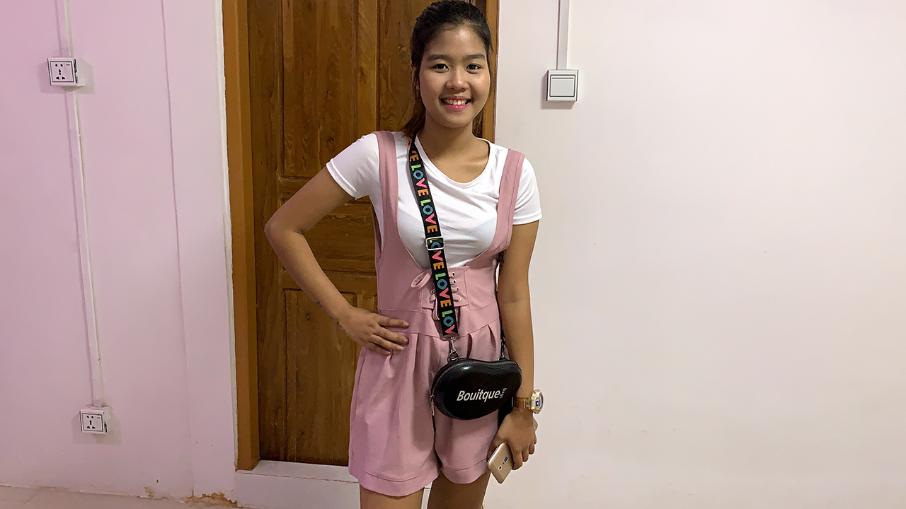 Shy Filipina Sandy B standing in pink jumpsuit overalls