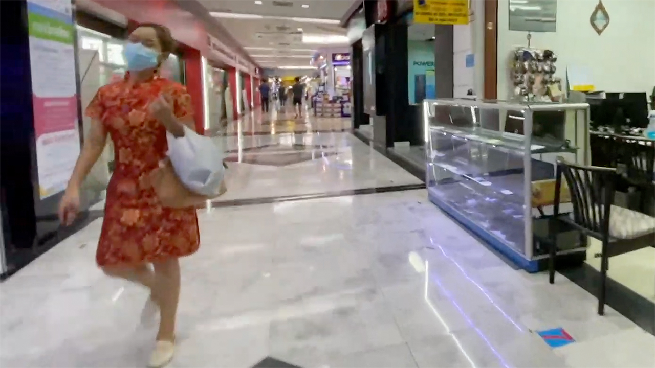 Pretty Girl In Thai dress and facemaskw alking in mall