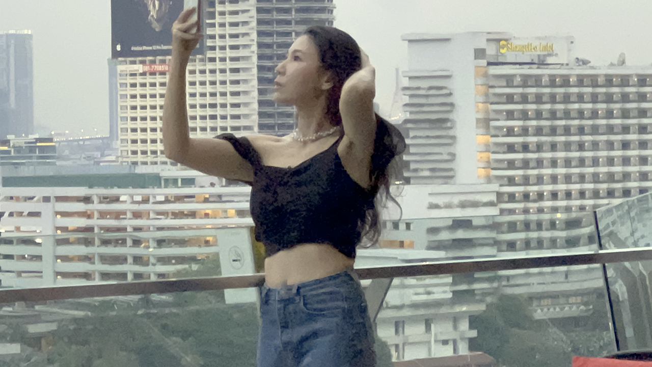 Hot Asian girl taking selfie on top of Bangkok Riverview restaurant