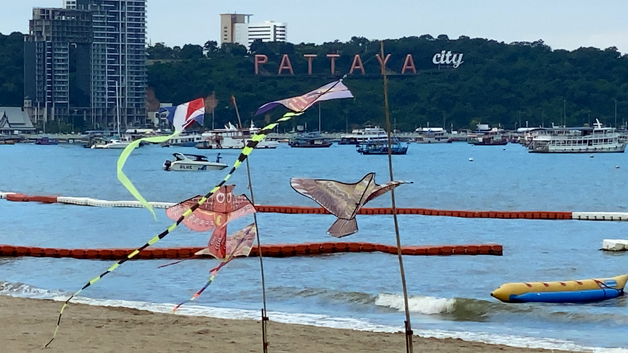 Kites on Pattaya Beach with Pattaya City sign in background