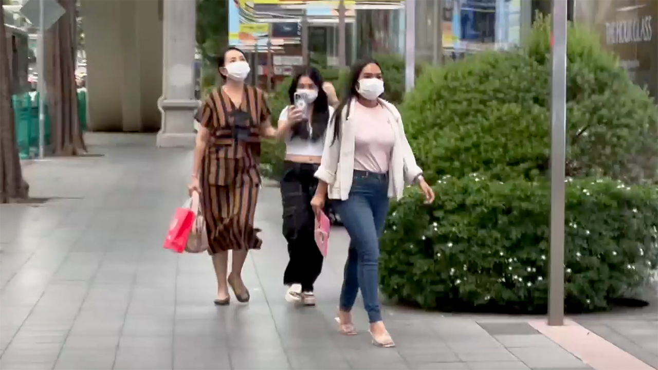 3 Thai girls walking through Central World Bangkok mall