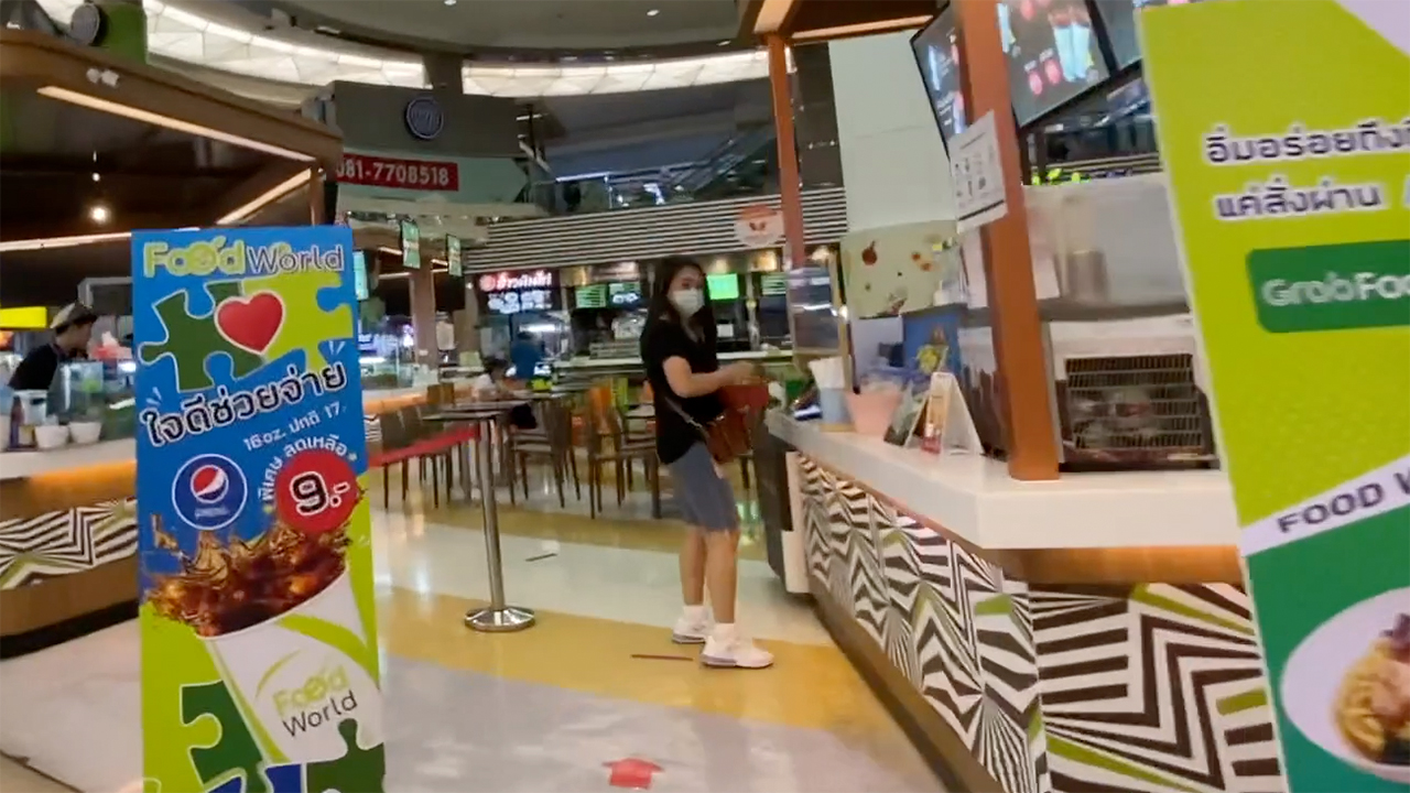 Girl stands at food counter while shopping for Christmas In Bangkok
