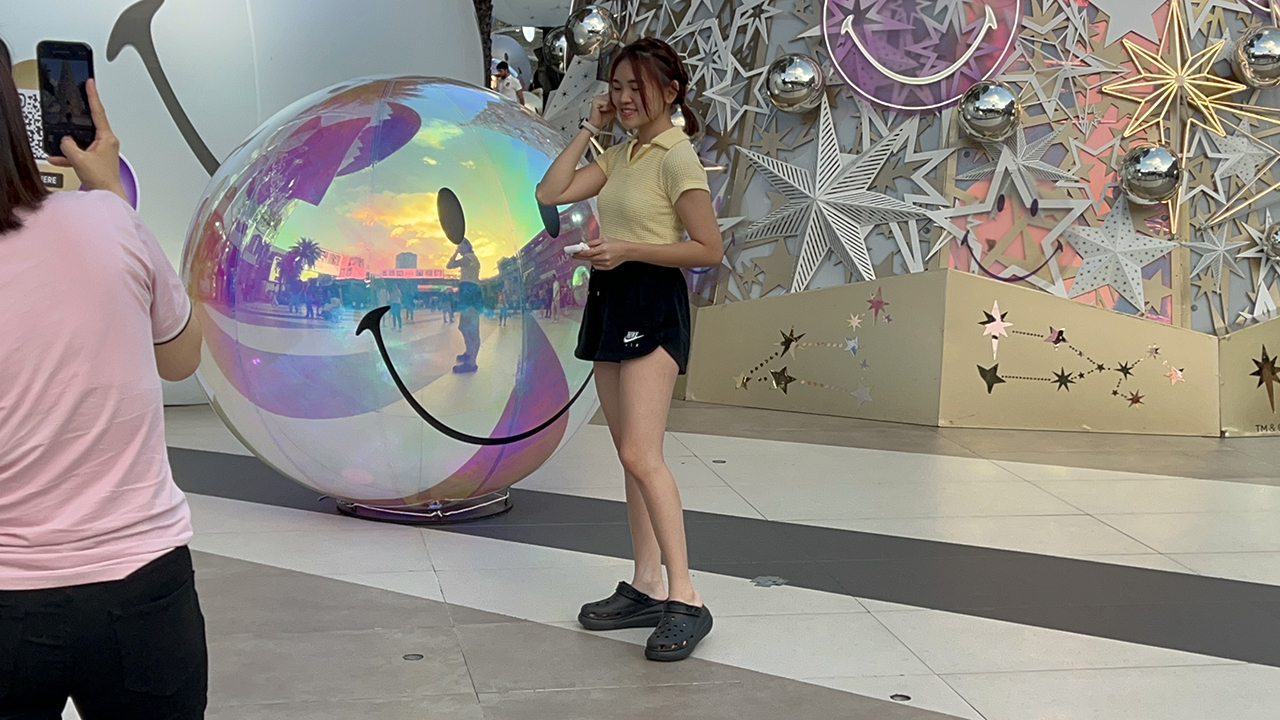 Thai girl poses near Paragon Christmas tree and giant ornament