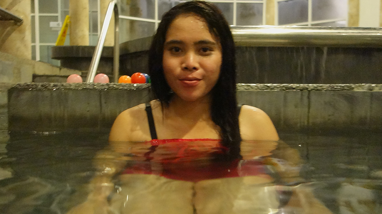 Mya sits in water at Yangon Bath House