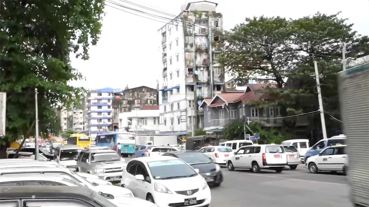 View of road and old apartment building in Yangon Slums