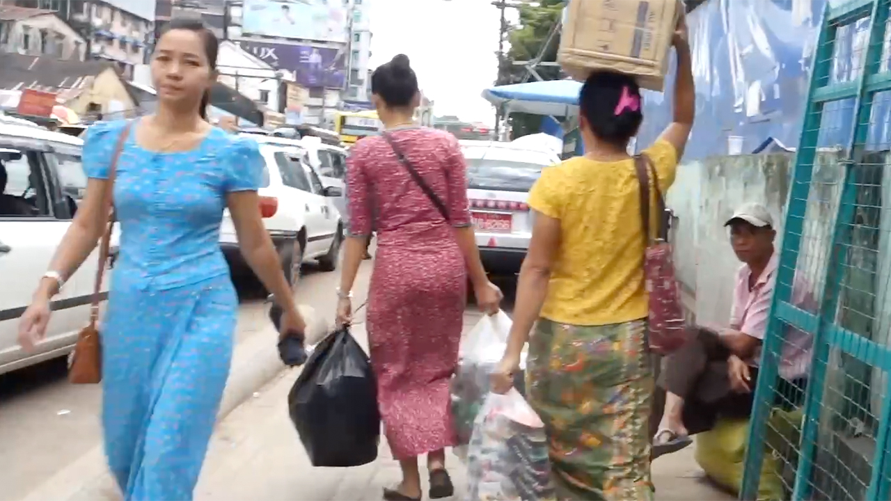 Pretty Burmese Girls walkig on sidewalk of Yangon Market