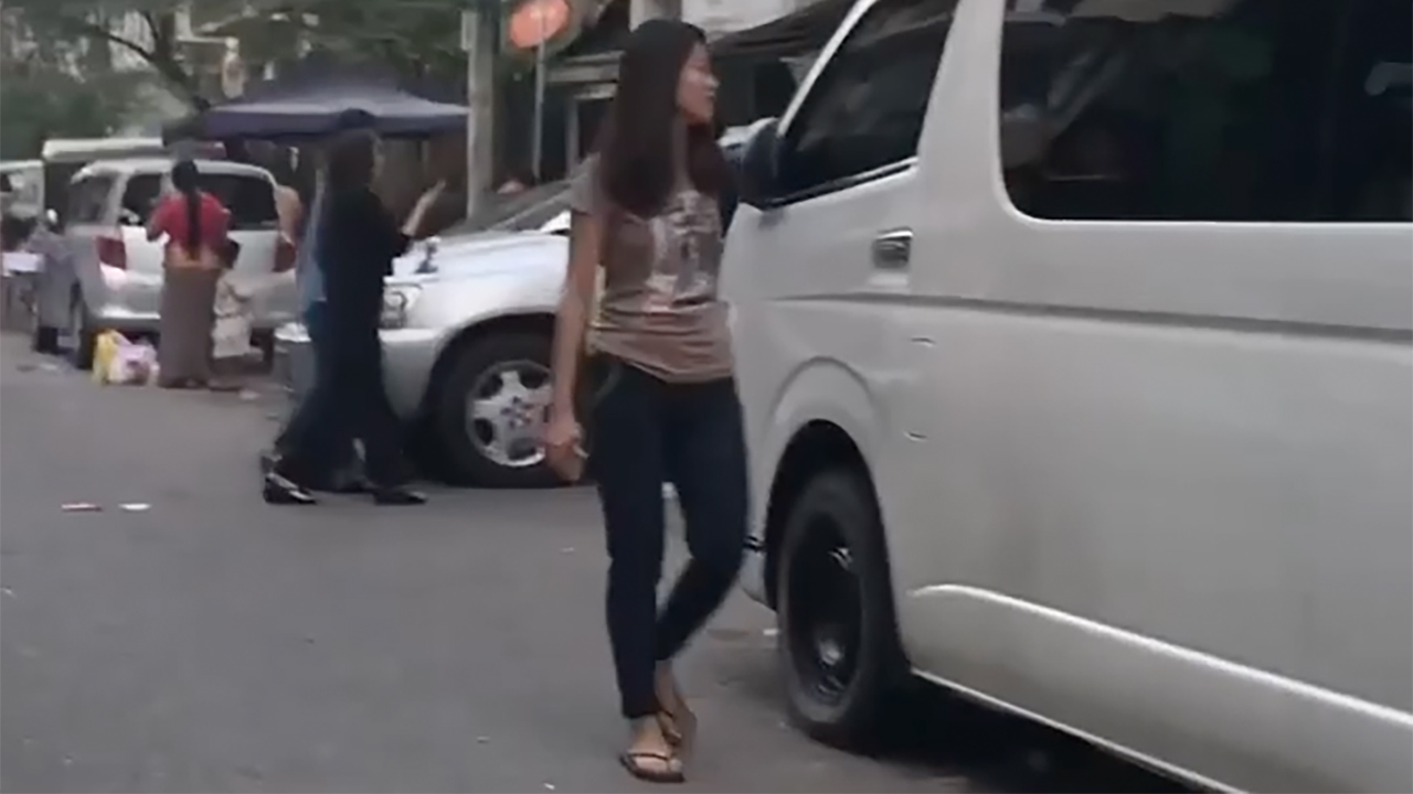 Burmese girl stands by van during Yangon Charity Festival