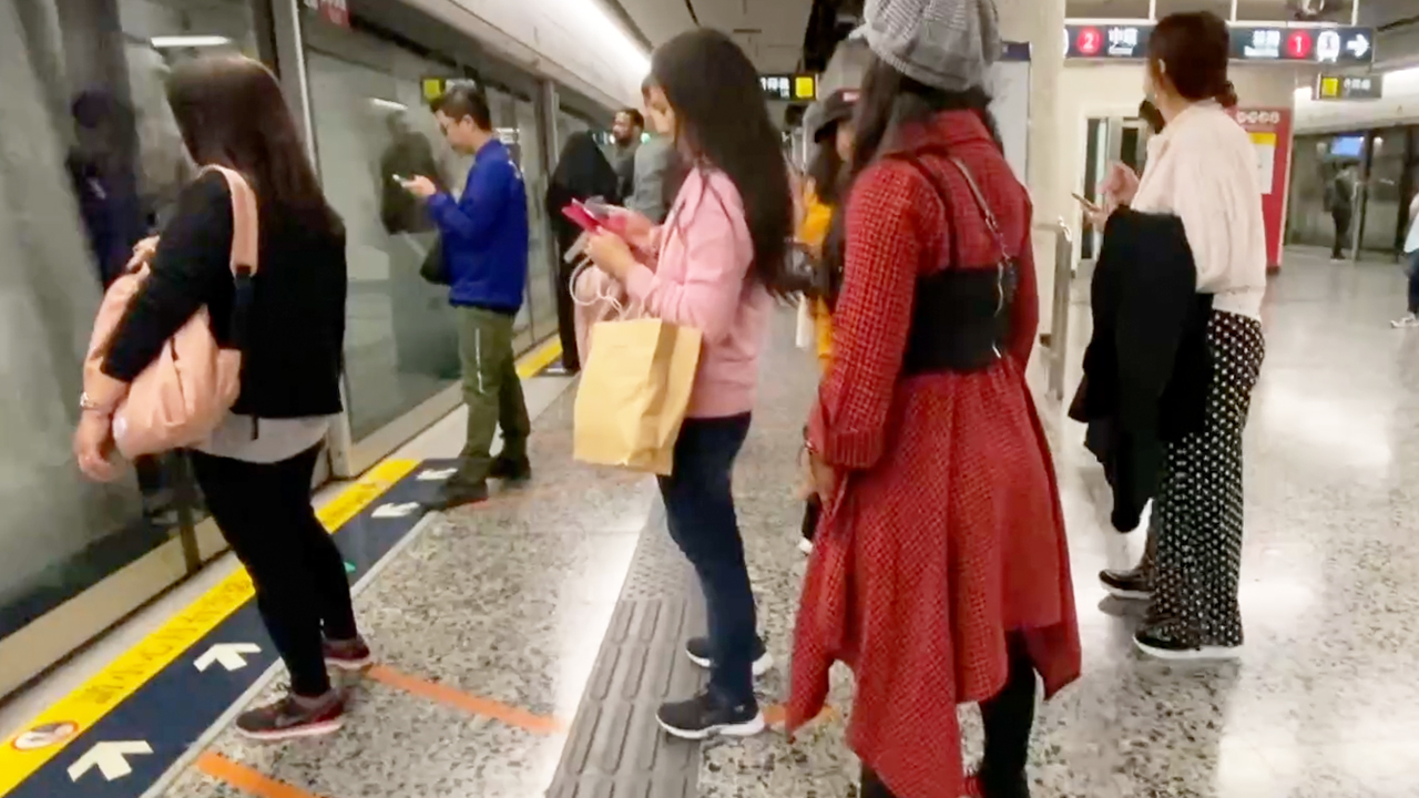 Hong Kong MTR Girls on platform with one in pink texting