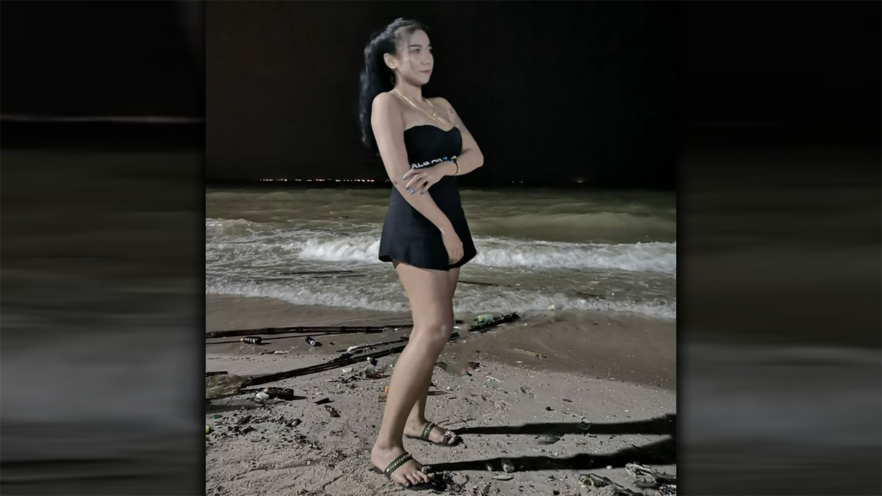King D poses for pic of Asian On The Beach in short black dress
