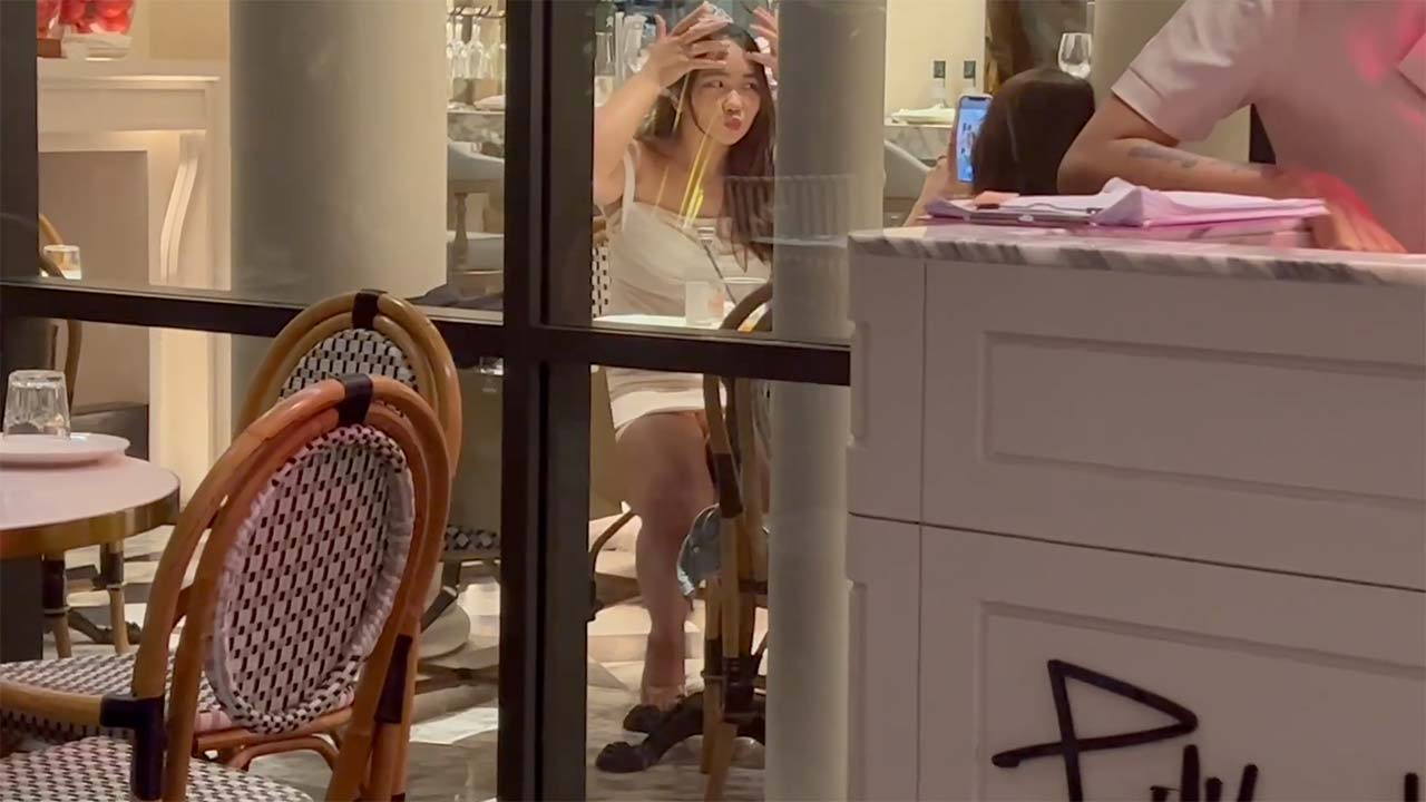 Asian Girl In Short dress watched through restaurant window