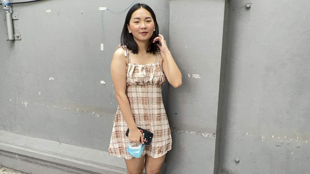 Pretty Thau standing in cute short dress on sidewalk