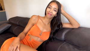 Lia Lin XXX actress sits on couch in revealing dress