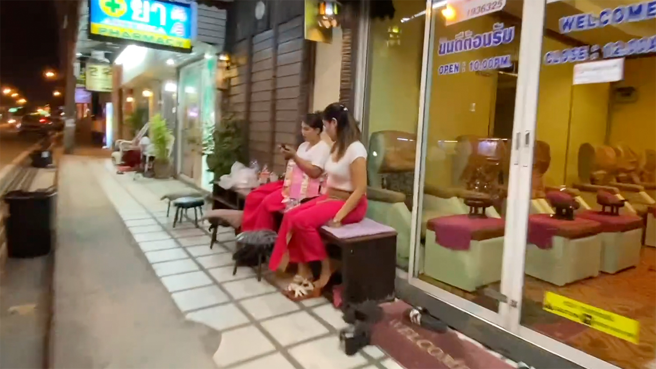 Girls from Thai Foot Massage business sit outside
