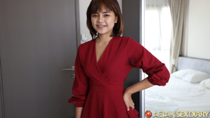 Cute Asian in red dress smiling at camera