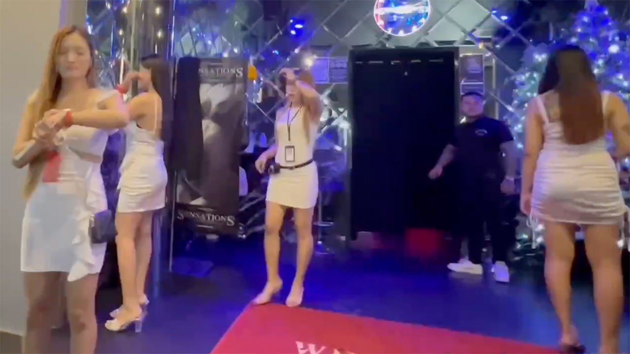 Thai girls wearing white Slutty Dresses in front of a club