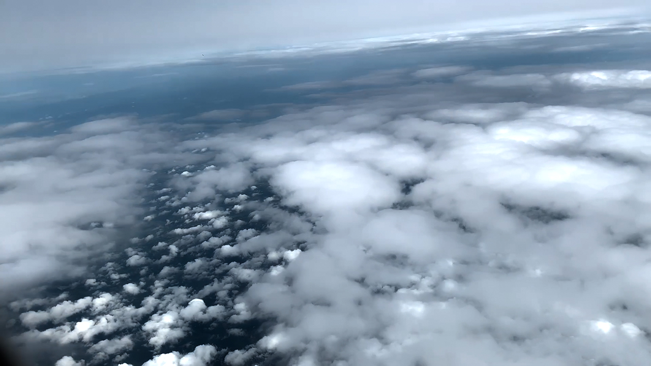 View Above Clouds From A Plane in flight to Bangkok