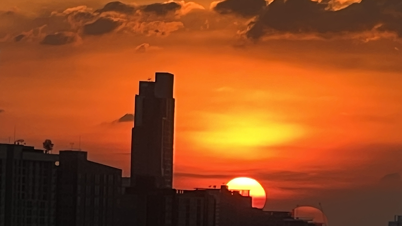 Red sun above buildings in beautiful THAI SUNSET captured in Bangkok Thailand