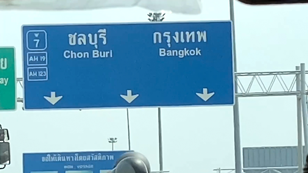 View of highway sign from window while Driving To Bangkok