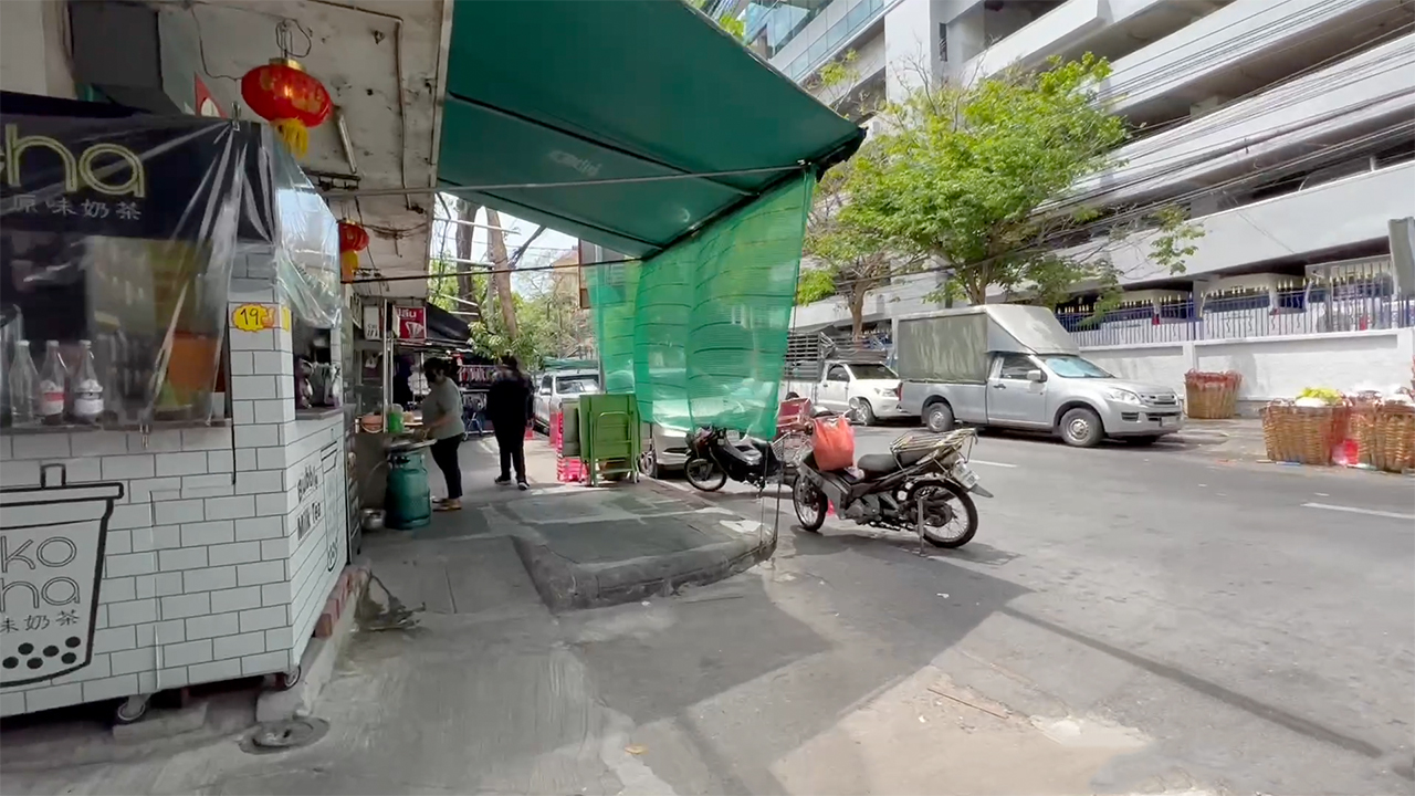 View of sidewalk and street along a Bangkok Chinatown streen