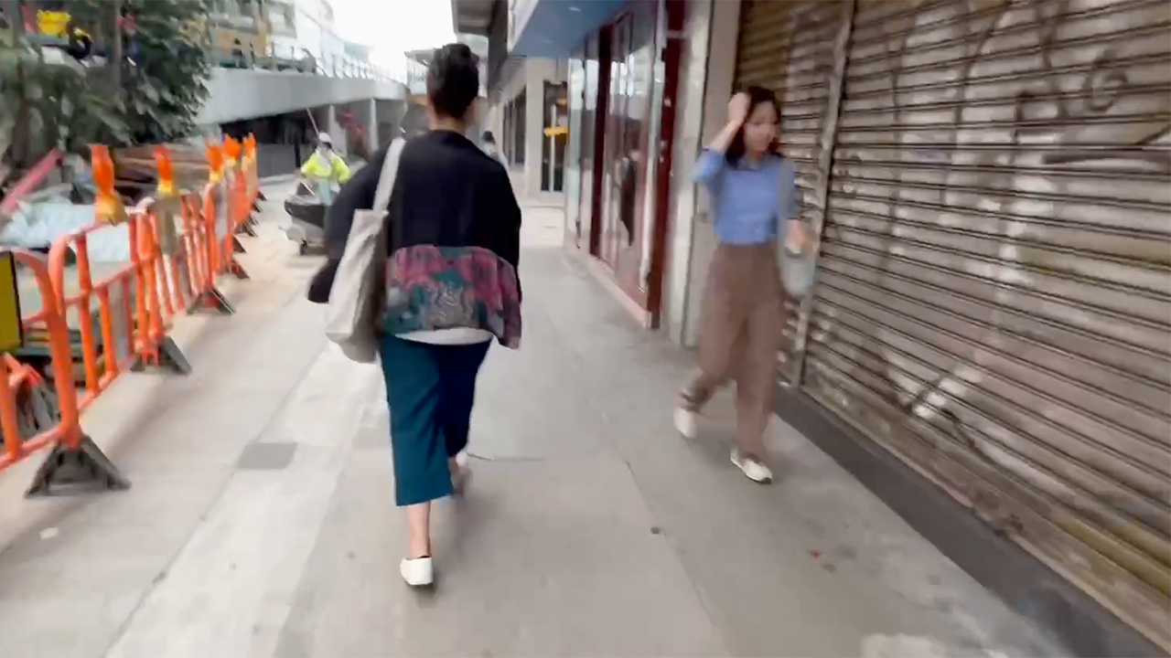 Girls viewed on sidewalk during walk and hunt for Hong Kong Noodles