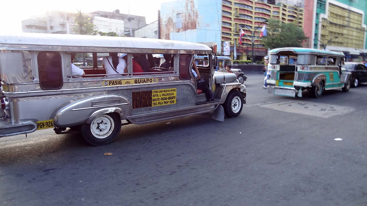 Jeepney drives by on road on way to Quiapo Manila