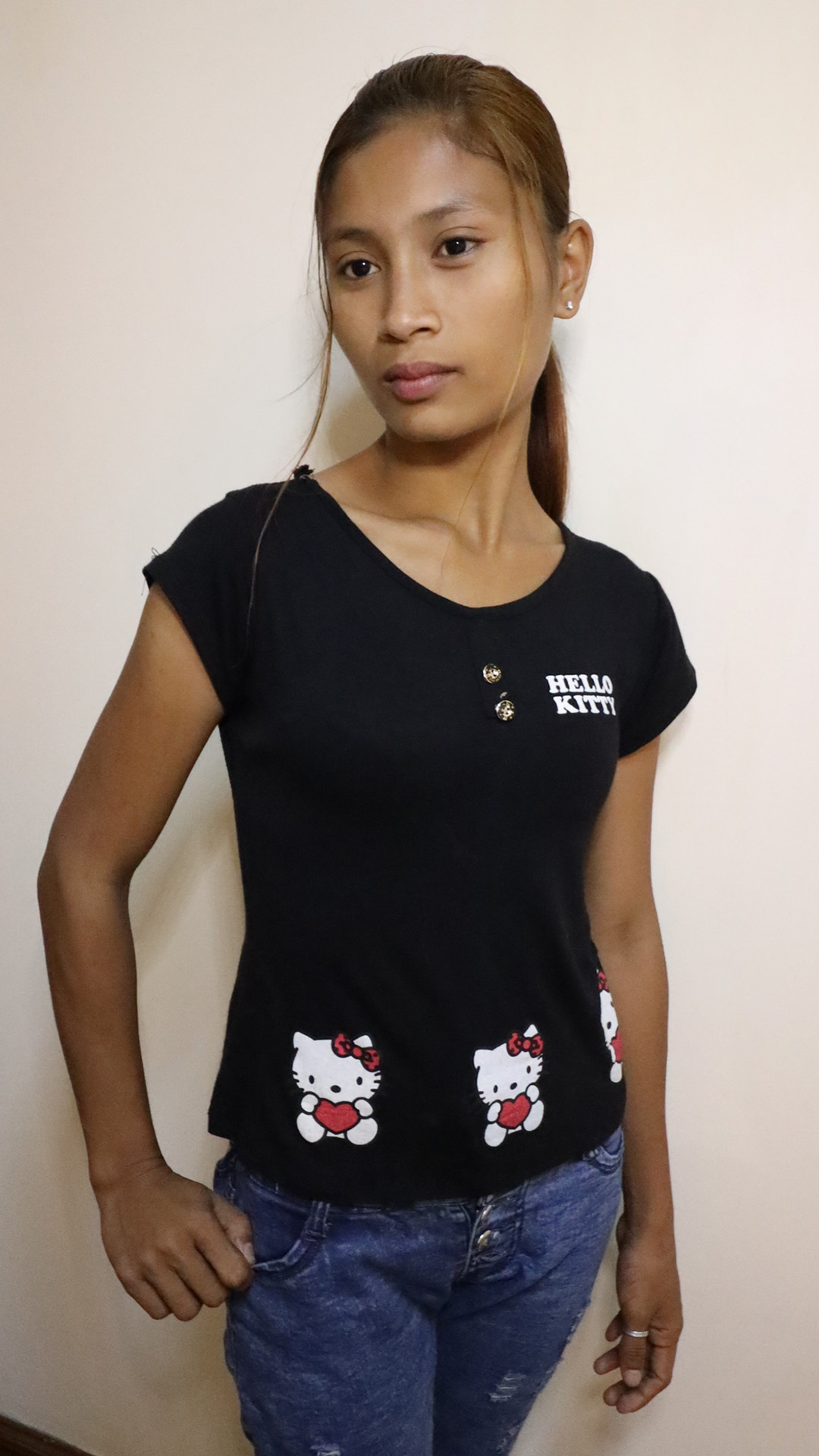 Asian Sex Diary Kemala B poses for camera in Hello Kitty shirt and blue jeans