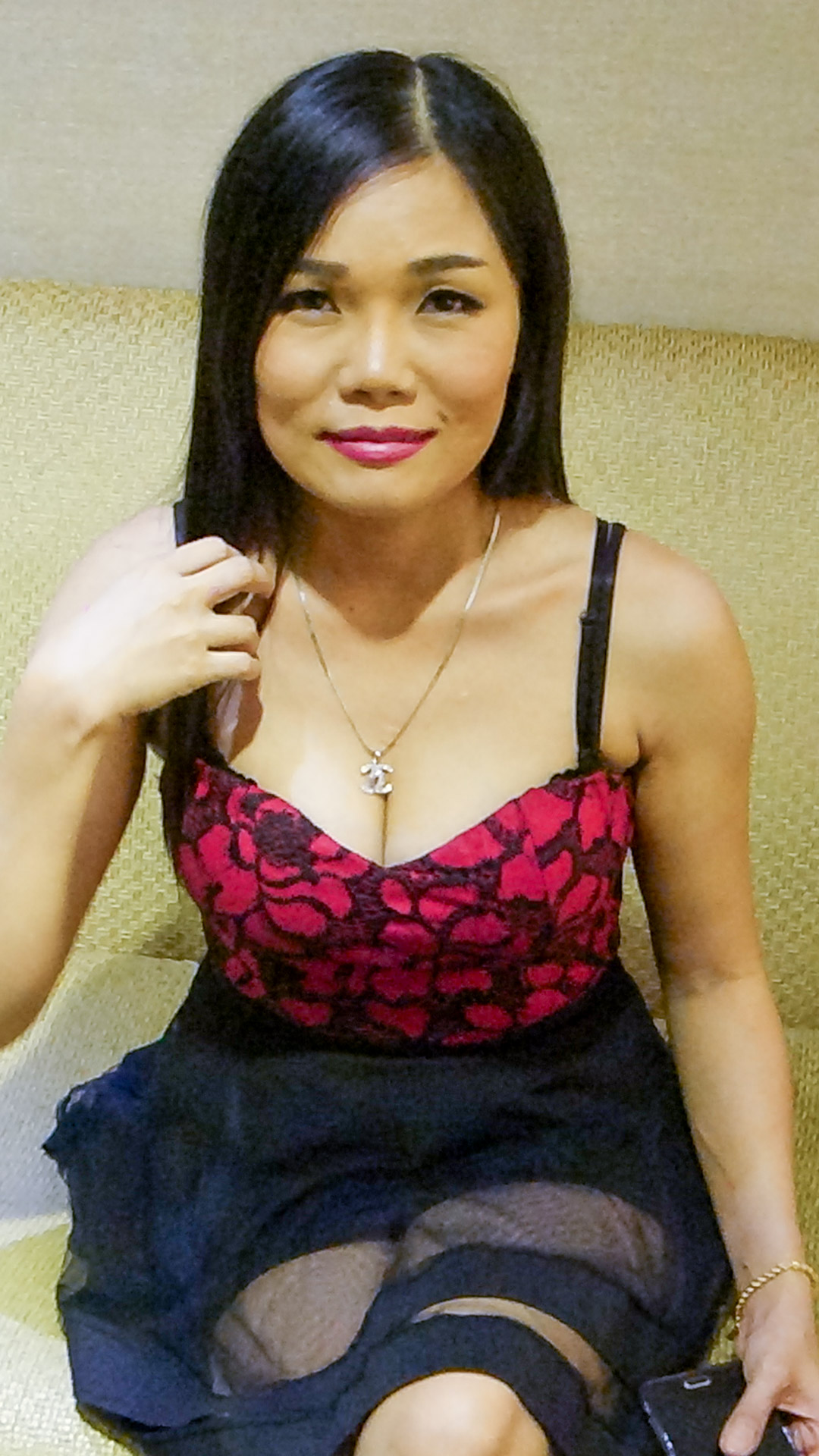 Sexy milf Asian Sex Diary Yen D poses on the couch in lacy dress