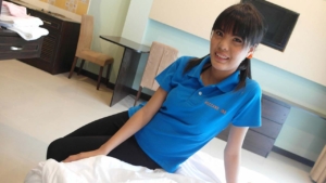 Korean Maid sitting on my hotel bed and smiling at me