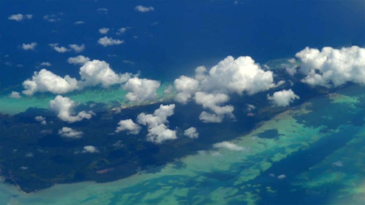Blue ocean and puffy clouds from window my my Flight To Manila