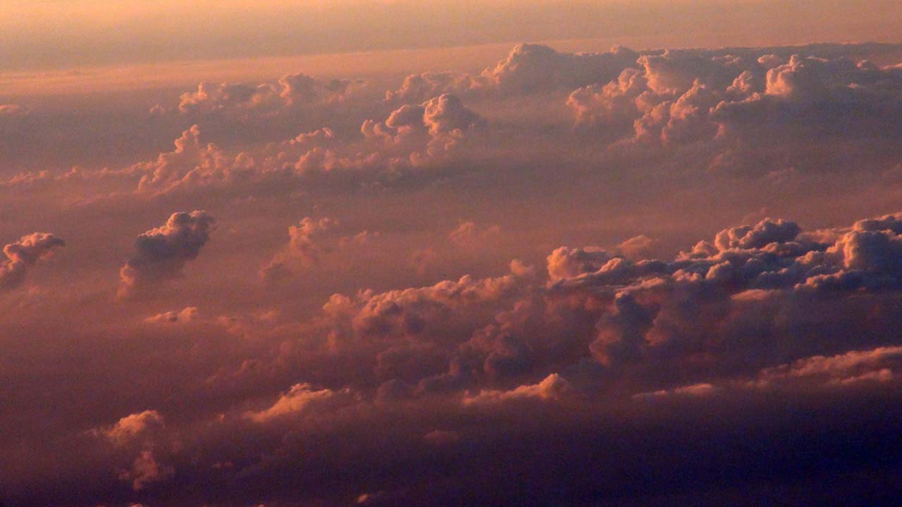 View of red sunset clouds from window of plane on Flight Out Of Europe